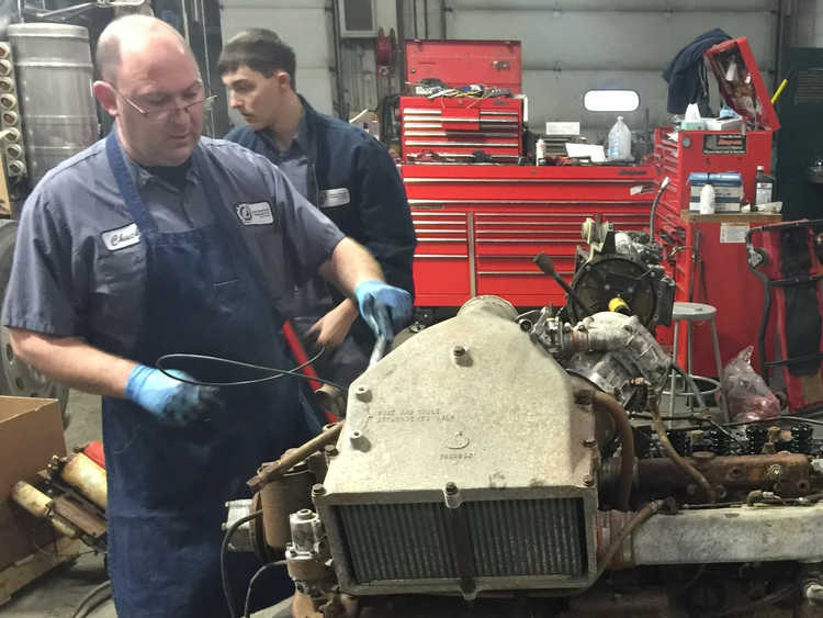 Mechanics Restoring Vintage Motorcycle Engine